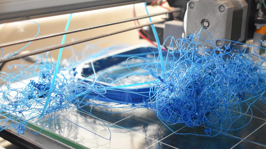 Failed 3D print attempt showing a messy tangle of blue filament spaghetti on a build bed in St Catharines, Niagara Region.